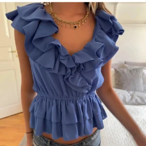 Blå volangblus - Säljer en söt blå blus med volanger och elastisk midja. Aldrig använd är i jätte bra skick ! 🩷strl S-  36 jag som har S passar perfekt. 