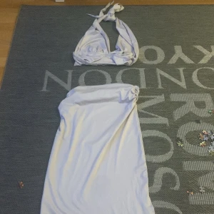 Vit topp med knytband - Snygg vit bikini med knytband. Överdelen har breda band som knyts i nacken och ryggen. Underdelen är enkel och matchar toppen perfekt. Perfekt för en dag på stranden eller vid poolen.