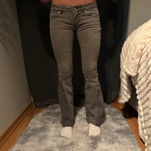 Grå bootcut jeans - Snygga grå bootcut jeans med låg midja och klassisk femficksdesign.                         Lågmidjade bootcut  Omsydda jeans Grenmått: 17 cm Midjemått: 33 cm Innerbenslängd: 71 cm