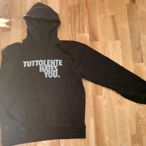 Tuttolente - Tuttolente Hates You hoodie i nyskick. Säljer eftersom den var för stor och har bara blivit använd en gång. Köpt för 1100kr och går ej att få tag i längre. Skriv för mer bilder eller om du har frågor!💫