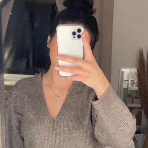 Beige/ brun stickad tröja med v-ringning - Säljer en mysig beige stickad tröja med v-ringning. Perfekt att ha som en off shoulder,    med sin ribbade struktur och långa ärmar. Hör av dig vid intresse! 
