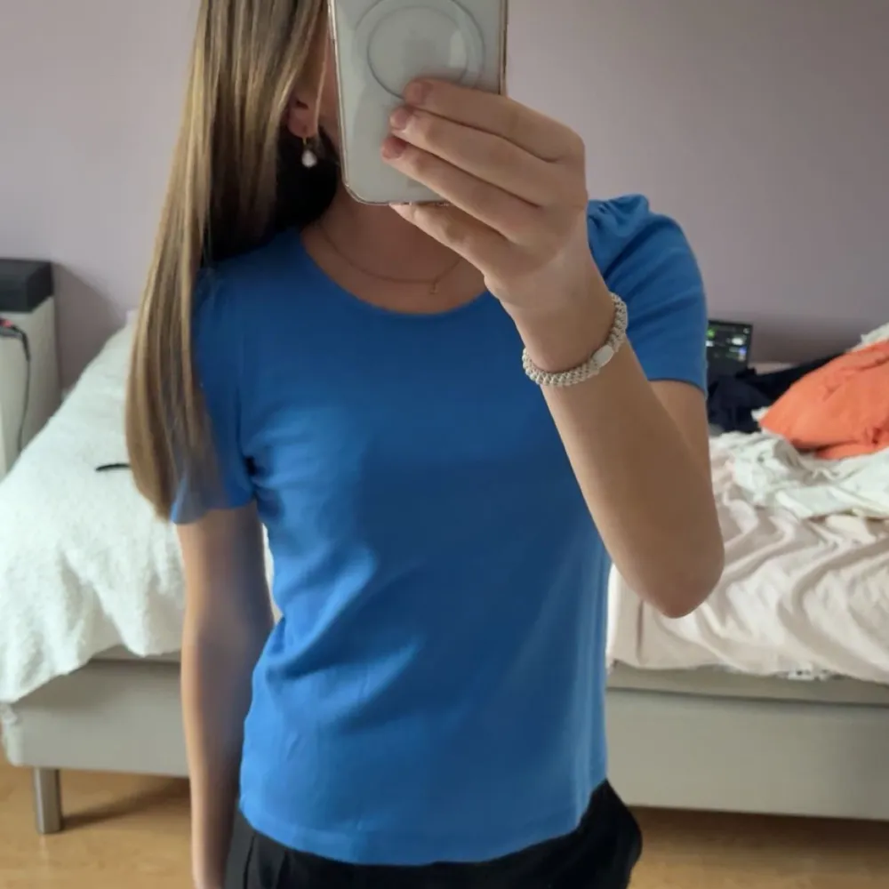 Säljer en blå t-shirt med korta ärmar med volang på axlarna. Skriv för flera bilder . T-paidat.