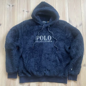 Ralph Lauren Hoodie - En riktigt skön och sällsynt hoodie från Ralph Lauren. Skicket är jättebra och den har inga defekter. Storleken är S och den är mörkblå med vit text. Väldigt skön att ha på sig, tveka inte vid någon fråga 🙌