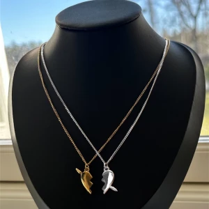 Maria Nilsdotter you and me inspererat halsband  - Inspererat halsband av Maria Nilsdotter. Två matchande silver och guldhalsband med delade hjärthängen. Perfekt för att dela med en vän eller partner. Kedjorna är 40cm med går att förlänga med ytligare 5 cm. Vid mer frågor är det svar att höra av sig ☺️