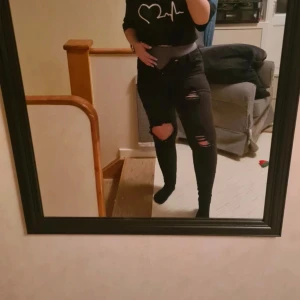 Svarta slitna jeans 5 (XS/S) - Högmidjade svarta jeans med slitningar, storlek 5 (jag hade sagt närmre S än XS) från Fashion nova. Använda enstaka gånger Fickor fram och bak, alla funkerande. Blixtlåset funkar bra. Väldigt stretchiga och mjuka i tyget!  Kläderna rollas innan dom skickas då katt finns i hemmet!  #jeans #svartajeans #blackjeans #slitnajeans #wilmabookss #wilmabooksstorleks