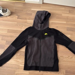 Nike tech fleece tröja  (349kr bara idag!) - (349 kronor  bara idag‼️‼️‼️!!!!)Nike tech fleece tröja o svart/grå med gul/grön nike logga i storlek S. Knappast använd. Nypris runt 1000-1100. 