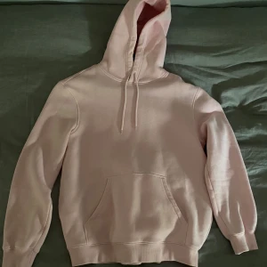 Ljusrosa hoodie - Säljer en enkel och stilren ljusrosa hoodie med huva och dragsko. Den är knappt använd och i perfekt skick😊