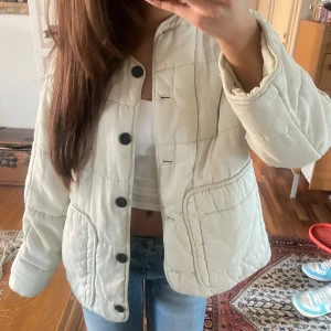 Vit quiltad jacka från Zara - Lånade bilder från förra ägaren!💗 Säljer en snygg vit quiltad jacka från Zara med stora svarta knappar. Jackan har en avslappnad passform och är perfekt för kyligare dagar. Den har långa ärmar och en stilren design som passar till många olika outfits. Passar xs-m. använd gärna köp nu❣️
