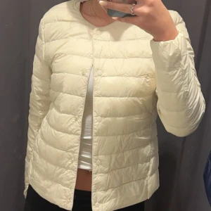 Ljusgul pufferjacka - Säljer en ljusgul pufferjacka med rund halsringning och diskreta knappar framtill. Jackan är lätt vadderad och har lång ärm, perfekt för övergångssäsonger. Enkel och stilren design som passar till mycket❤️
