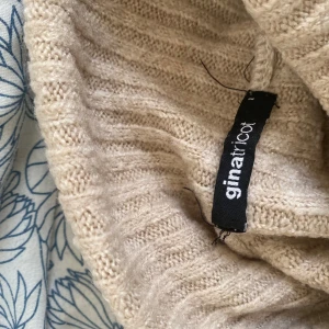 Söt croppad stickad tröja ☺️ - Säljer en beige ribbad stickad tröja från Gina Tricot. Tröjan är croppad med lång ärm och har en bred krage. 