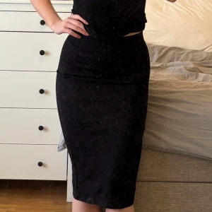 Svart tight midikjol - Säljer en svart tight kjol med midilängd. Kjolen har en enkel och stilren design utan ärmar och passar perfekt till dig som gillar en klassisk look. Materialet känns mjukt och följsamt mot kroppen.