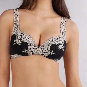 Svart spets-bh från instimissimi - Snygg svart bh från intimissimi med vacker beige spets och broderade blommor. Den är i jättefint skick och väldigt sparsamt använd! Säljer pga att jag behöver byta storlek. Nypris 600, frakten på hemsidan 100kr, ofta slutsåld