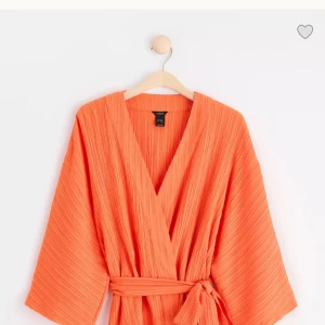 Orange omlottklänning med knytband - Säljer en orange omlottkimono med knytband i midjan. Perfekt för sommarens alla tillfällen! Så så fin och passar med så många outfits🫰🏼
