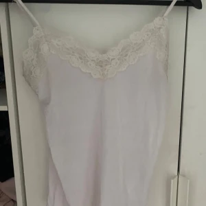 Vit spetslinnetopp från Object - Säljer en söt vit linnetopp från Object med fina spetsdetaljer längs urringningen och axelbanden. Toppen har en feminin och romantisk känsla, perfekt att styla till olika outfits.