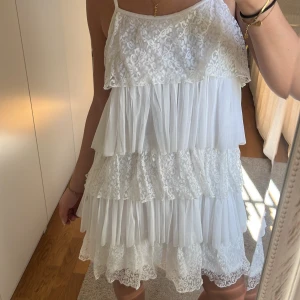 Vit volangklänning med spetsdetaljer - Ass snygg vit volang klänning!! Super fina detaljer och passar PERFEKT till studenten och i sommar🩷🩷🩷