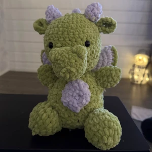 Virkat gosedjur - En supergullig och kramgo gosedjurs drake! Gjort på mjukt och fluffigt garn i färgerna lila och grön. Vid frågor är det bara att skriva!