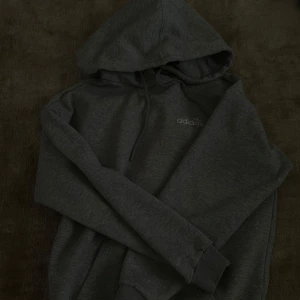 Grå hoodie från Adidas - Säljer en grå hoodie från Adidas med klassisk logga på bröstet och ryggen. Tröjan har huva och långa ärmar. 🤍