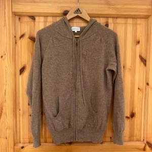 Beige cashmere hoodie från Davida - Cashmere hoddie från davida. Nästan aldrig använd men min hund har råkat förstöra lite på ena snöret som ni kan se på sista bilden, annars väldigt fint skick. Org pris 2800