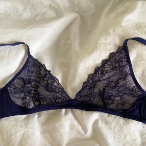 Mörkblå spets-bh från Monki - Säljer en mörkblå bh från Monki i storlek XS. Bh:n är i mjuk spets med fina blommiga detaljer och tunna axelband. Perfekt för dig som gillar en lätt och bekväm känsla.