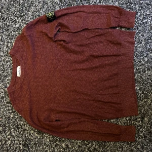 Vinröd tröja från Stone Island - Säljer en vinröd långärmad tröja från Stone Island. Tröjan har rund halsringning och ribbade muddar vid ärmslut och nederkant. Aldrig använd.