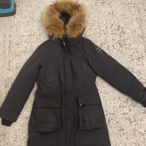 Lexington vinterjacka (dam) - Jag har använt den, men den är fortfarande i bra skick och håller värmen väldigt bra. Den fäller lite och en ficka är lite trasig. Köpte den för 6000 kr.     Priset kan diskuteras