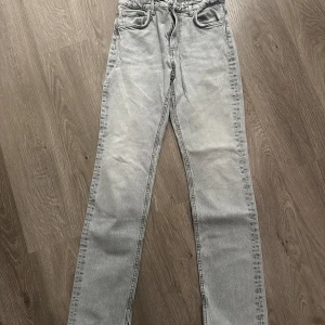 Grå jeans från Zara - Säljer ett par snygga grå jeans från Zara i storlek EUR 36. De har en straight passform och är tillverkade i ett bekvämt denimtyg. Perfekta för både vardag och fest! De har en  slits vid bensluten som ger en cool touch.