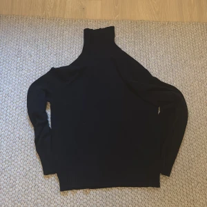 Mörkblå polotröja h&m - Säljer en mörkblå polotröja med lång ärm. Tröjan har en hög krage och är i ett mjukt material som passar perfekt till kyligare dagar. Enkel och stilren design som funkar till det mesta.