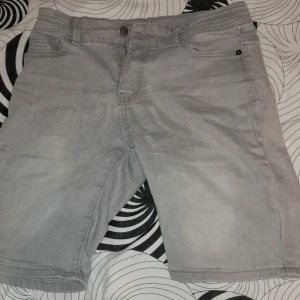 Ljusgrå jeansshorts från D.M.D by denim day - Snygga ljusgrå jeansshorts med klassisk femficksdesign och dragkedja. Perfekta för varma dagar och enkla att matcha med olika stilar. Märke: D.M.D by denim day.