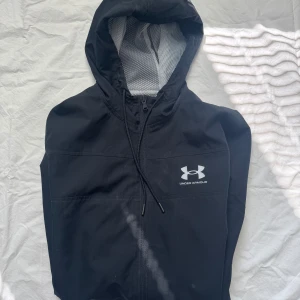 UNDER ARMOUR - säljer denna feta under armour windbreakern. Det är i bra skick och passar perfekt nu till kalla sommar dagar.