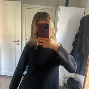 Svart stickad tröja med lös passform - Mysig svart stickad tröja med lång ärm och lös passform. Tröjan har en enkel design utan synliga detaljer.