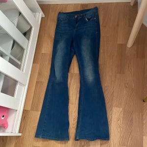 Blå bootcut jeans från Bubbleroom - Snygga blå bootcut jeans från Bubbleroom med klassisk femficksdesign och dragkedja. Jeansen har utsvängda ben och normal passform. Medelhögmidja och de är väl använda. Köptes för 499kr. Finns inte kvar i sortimentet. 