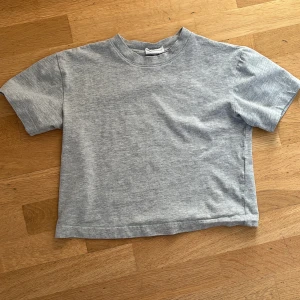Grå T-shirt från Gina Tricot - Jättesnygg grå T-shirt från Gina Tricot. Perfekt för en avslappnad look💕