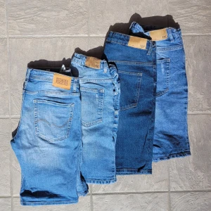PAKET 4 par Jeansshorts från Jack & Jones och 157 - 4 par jeansshorts i olika blå nyanser från Jack & Jones och 157. Snygg Slimfit o rak femficksmodell med gylf. Och dolda resårband i midjan om man behöver justera. Två av dem har slitna detaljer och olika tvättar, från ljus till mörk denim. Storlek 150 1 par, 160 2 par, 164 1 par. Säljs helst som paket 200kr för alla! Annars 70kr styck.