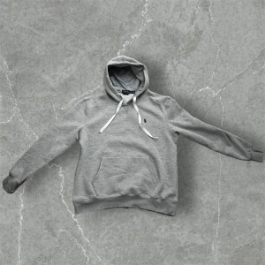 Grå hoodie från Polo Ralph Lauren  - Säljer en grå hoodie från Polo Ralph Lauren i storlek XXL .Hoodien har huva med vita snören, klassisk känguruficka och den ikoniska broderade loggan på bröstet. Mjuk insida och relaxed passform, perfekt för chill dagar. Obs den är för liten i storleken så den passar L då den krympt i tvätten!!