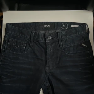 Replay Anbass jeans mörkblå W30 L30 1 INTRESSERAD!! - Snygga Replay Anbass jeans i mörkblå tvätt med klassisk femficksdesign och diskreta detaljer. Jeansen har normal passform och är tillverkade i mjukt denimtyg som sitter skönt hela dagen. Perfekta för dig som gillar stilrena och moderna jeans.