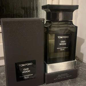 Tom Ford Oud Wood Eau de Parfum 100 ml - Elegant och lyxig parfym från Tom Ford, Oud Wood, i en stilren svart flaska på 100 ml. Doften är känd för sina rika och träiga noter, perfekt för den som söker en sofistikerad och unik doftupplevelse. Ca 85 ml kvar. Inga returer