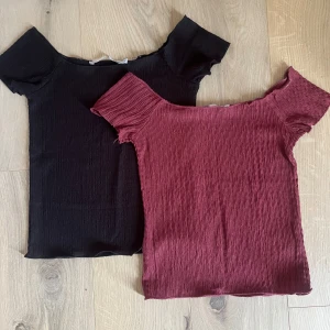 2 offshoulder toppar från 157, XS - Två snygga offshoulder toppar från 157 i storlek XS. En är svart och en är vinröd, båda i stretchigt, ribbat material med korta ärmar. Perfekta att styla med jeans eller kjol för en trendig look. Båda har tecken på användning uppe vid kanten men inget som synd vid användning. Skriv om ni skulle vilja köpa en av dom så går det att lösa! 💗super fina basic tröjor!