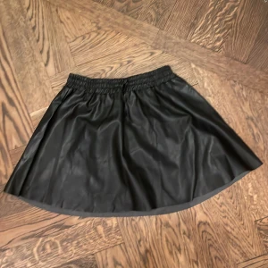 Svart skinnkjol Zadig & Voltaire -  svart kortkjol i skinn från Zadig & Voltaire. Kjolen har elastisk midja med snörning för extra komfort och en lätt utställd form. Storlek xs .