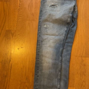 Jack & Jones skinny jeans ljusblå - Säljer ett par ljusblå skinny fit jeans från Jack & Jones, modell Liam. Jeansen har slitna detaljer och snygg tvätt med klassiska bakfickor. Perfekta för dig som gillar en tight passform och streetig look.