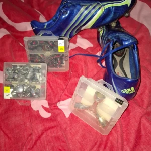 Adidas F50 blå fotbollsskor strl 42⅔ - Säljer ett par blå Adidas F50 fotbollsskor med gula och vita detaljer. Skorna har snörning och täckt plös, samt utbytbara dobbar och medföljande verktyg och extra dobbar. Perfekta för dig som vill sticka ut på planen!