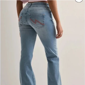 Ljusblå bootcut jeans med rosa detaljer - Säljer mina superfina ljusblåa jeans med en fin rosa detalj på fickorna då dom blivit förstora. Dom är använd 2-3 gånger och används inte nånting längre 💞