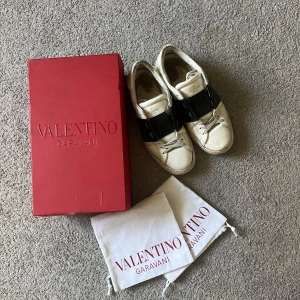 Valentino Garavani Open sneakers vit/svart - Skorna är väl använda och ganska slitna men funkar endå. Skulle säga skick 6/10 Skorna tvättas innan dem postas. Kom gärna med pris förslag och meddela innan köp.