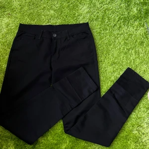 Svarta slim jeans med dragkedja - Svarta jeans med klassisk femficksdesign och gylf med guldfärgad dragkedja. Byxorna har bälteshällor och en slim passform som sitter snyggt längs benen. Perfekta till sneakers eller boots och funkar året runt.