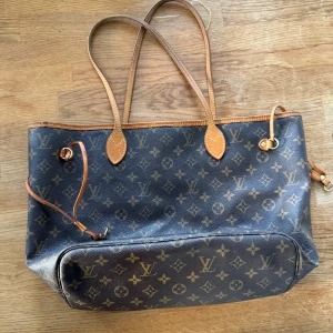 Neverfull - Äkta LV Neverfull MM Mycket vacker, i mycket gott skick, med några detaljer att notera: sömmen på ett av väskans axelband har lossnat lite, men det är lätt att fixa hos en väskreparatör eller liknande. Den lilla innerfickan flagnar, vilket händer med alla Neverfull-väskor vid användning. Den är lite smutsig på insidan, mestadels av smink och liknande. På grund av detta är priset mycket bra — passa på!