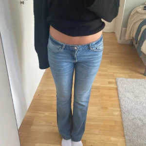 Lågmidjade ljusblå jeans från Bershka - Säljer ett par lågmidjade ljusblå jeans från Bershka i klassisk denim. Jeansen har raka ben med lätt bootcut och femficksdesign. Perfekta för dig som gillar 00-talsvibbar och vill ha en avslappnad men snygg look.