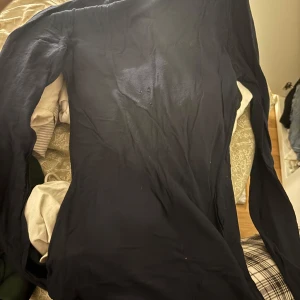 Mörkblå långärmad topp intimissimi - En basic mörkblå långärmad tröja i mjuk bomull. Tröjan har en enkel, rak passform och är perfekt för lager-på-lager. Stilren och lätt att matcha med jeans eller kjol. FINNS Liten defekt vid bröstet 