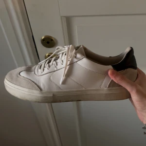 Vita sneakers från Vagabond - Snygga vita sneakers från Vagabond med detaljer i grå mocka och svart häl. Klassisk design med snörning och platt sula. Ovandel i skinn och mocka ger en clean och stilren look som passar till det mesta. Dom är knappast använda och nypris var 1200, skriv om ni har funderingar ❤️