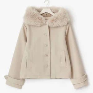 Beige kappa med fuskpäls-krage - Snygg beige kappa med fluffig fuskpäls runt kragen och stora knappar framtill. Jackan har raka ärmar med dekorativa knappar vid ärmslut och två fickor framtill. Perfekt för dig som vill ha en stilren och mysig look under kyliga dagar.