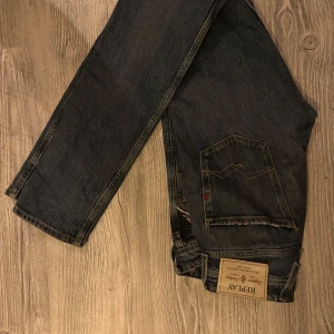 Replay Anbass jeans mörkblå herr - Säljer ett par Replay Anbass jeans i mörkblå tvätt med klassiska femficksdetaljer och snygga kontrastsömmar. Jeansen har normal passform och är tillverkade i slitstarkt bomullsmaterial. Perfekta för dig som gillar en tidlös och stilren look.
