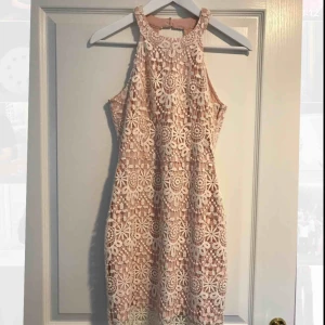  - En fin ljusrosa/vit spetsklänning med en öppning i ryggen ifrån Hollister. Använd endast 3 gånger, jätte fint skick! 